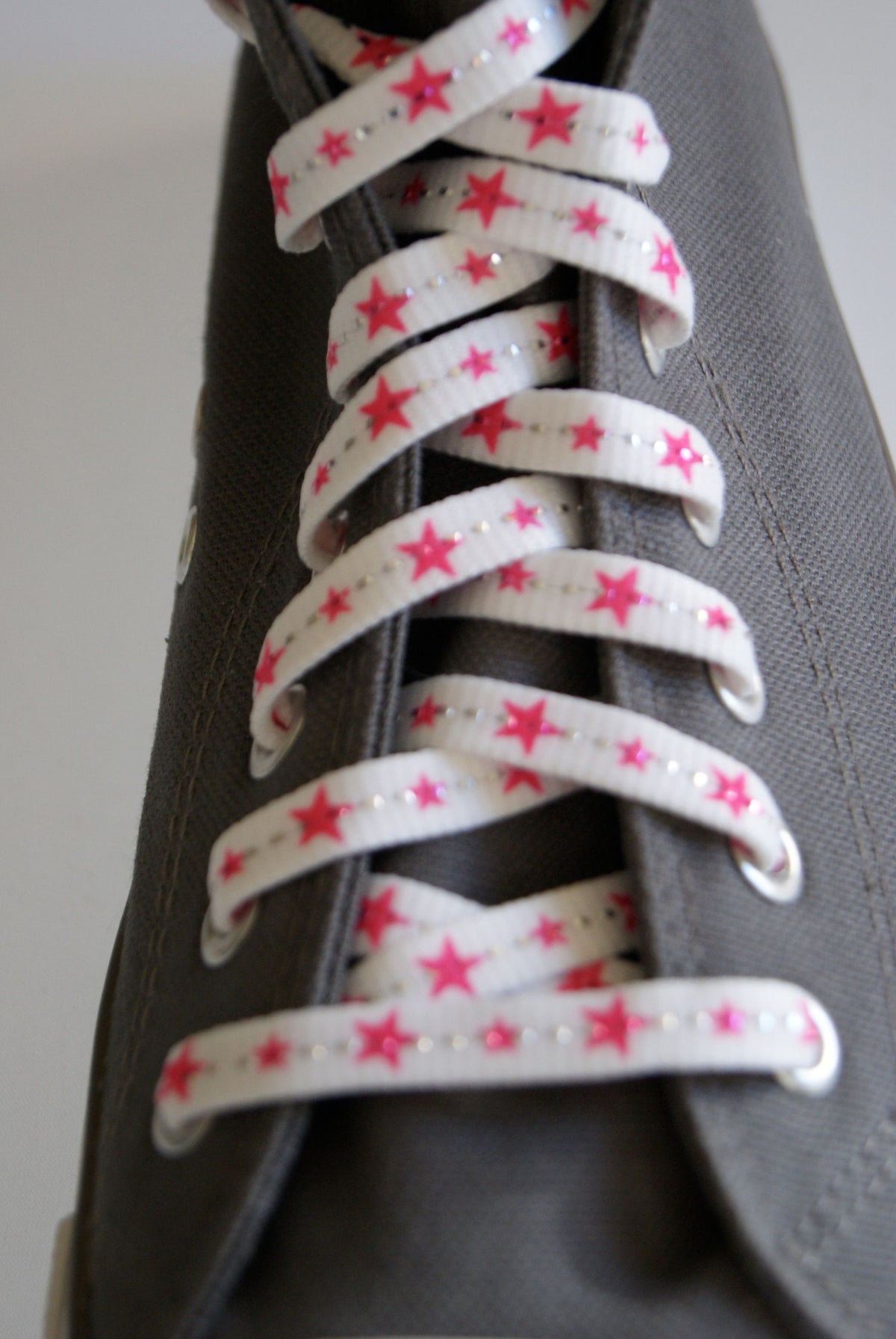 Lacets blancs et étoiles rose fluo