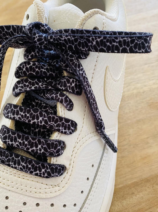 Light grey pop flower laces on a black background